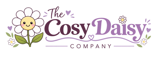 A stylized logo reading 'The Cosy Daisy Company' on a white background, featuring a smiling daisy illustration and decorative purple and green accents.
